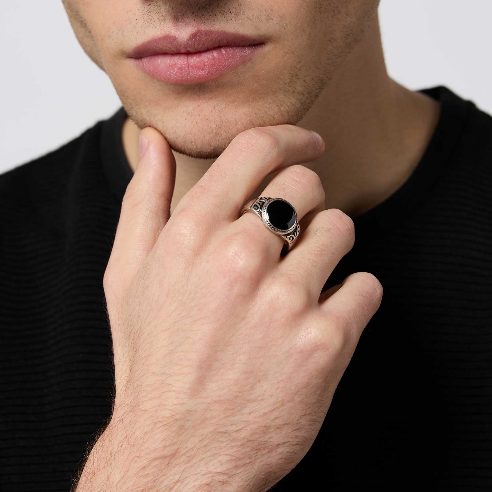 Silverfärgad ring med svart yta och mönster