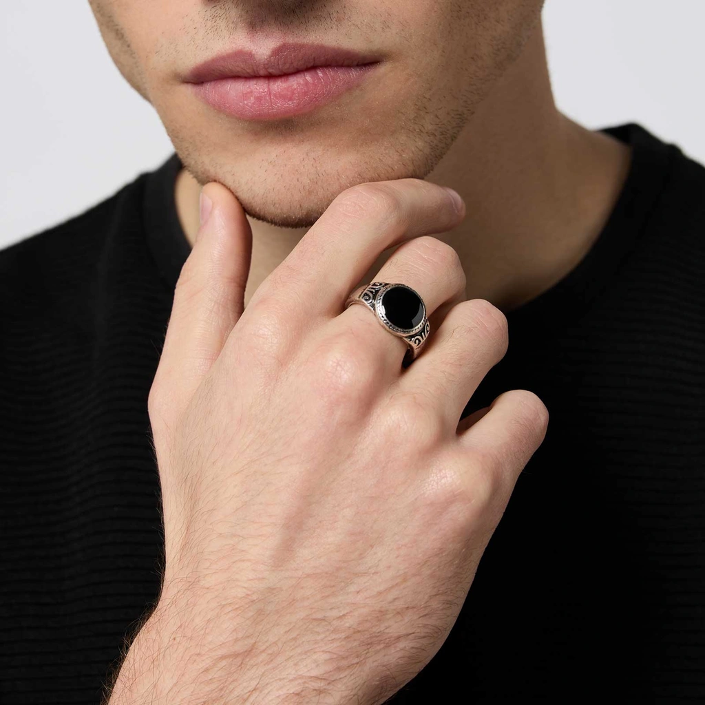 Silverfärgad ring med svart yta och mönster