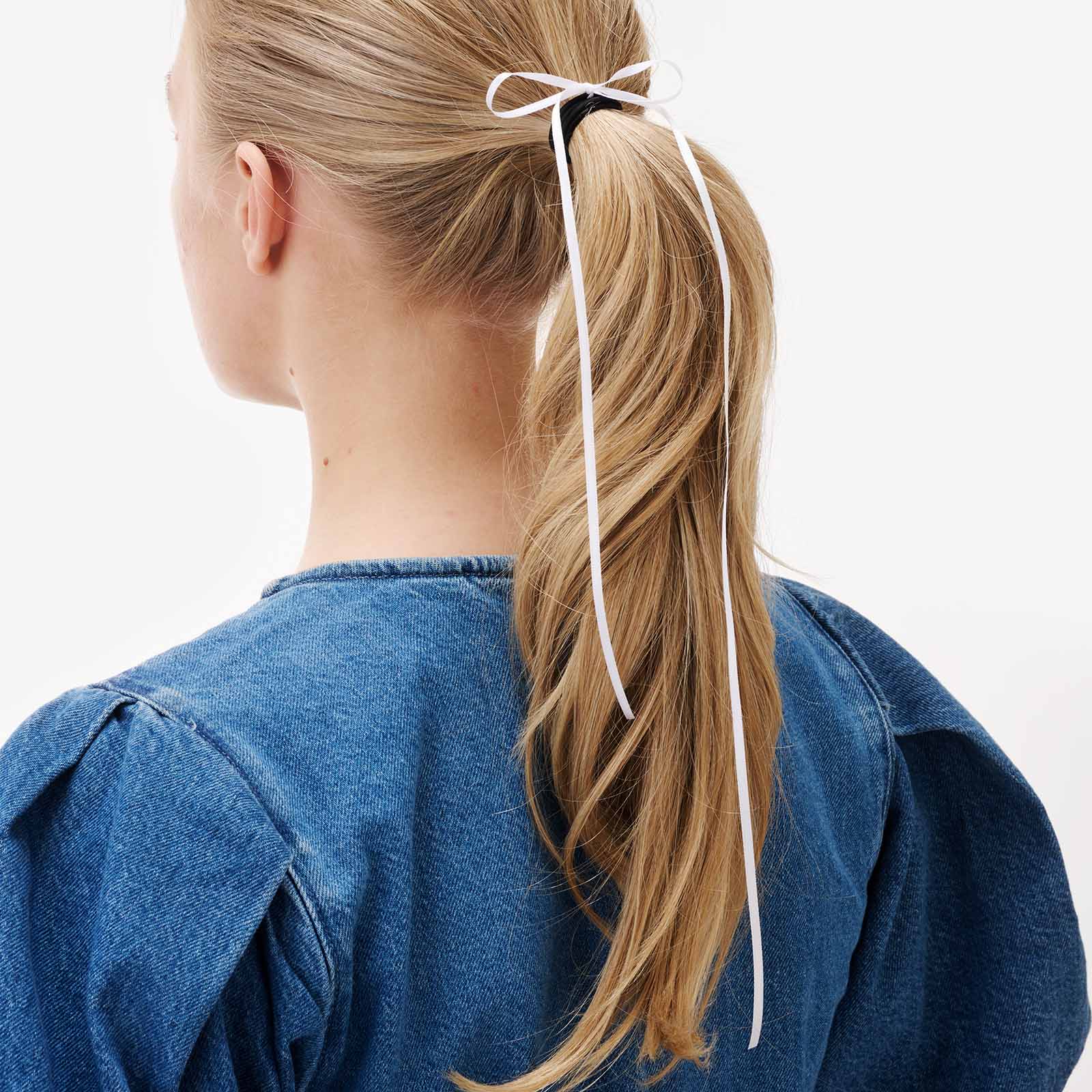 Svart gummisnodd med vit rosett