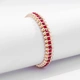 Guldfärgat armband Spike Noir, röda stenar med nitar - Elastiskt