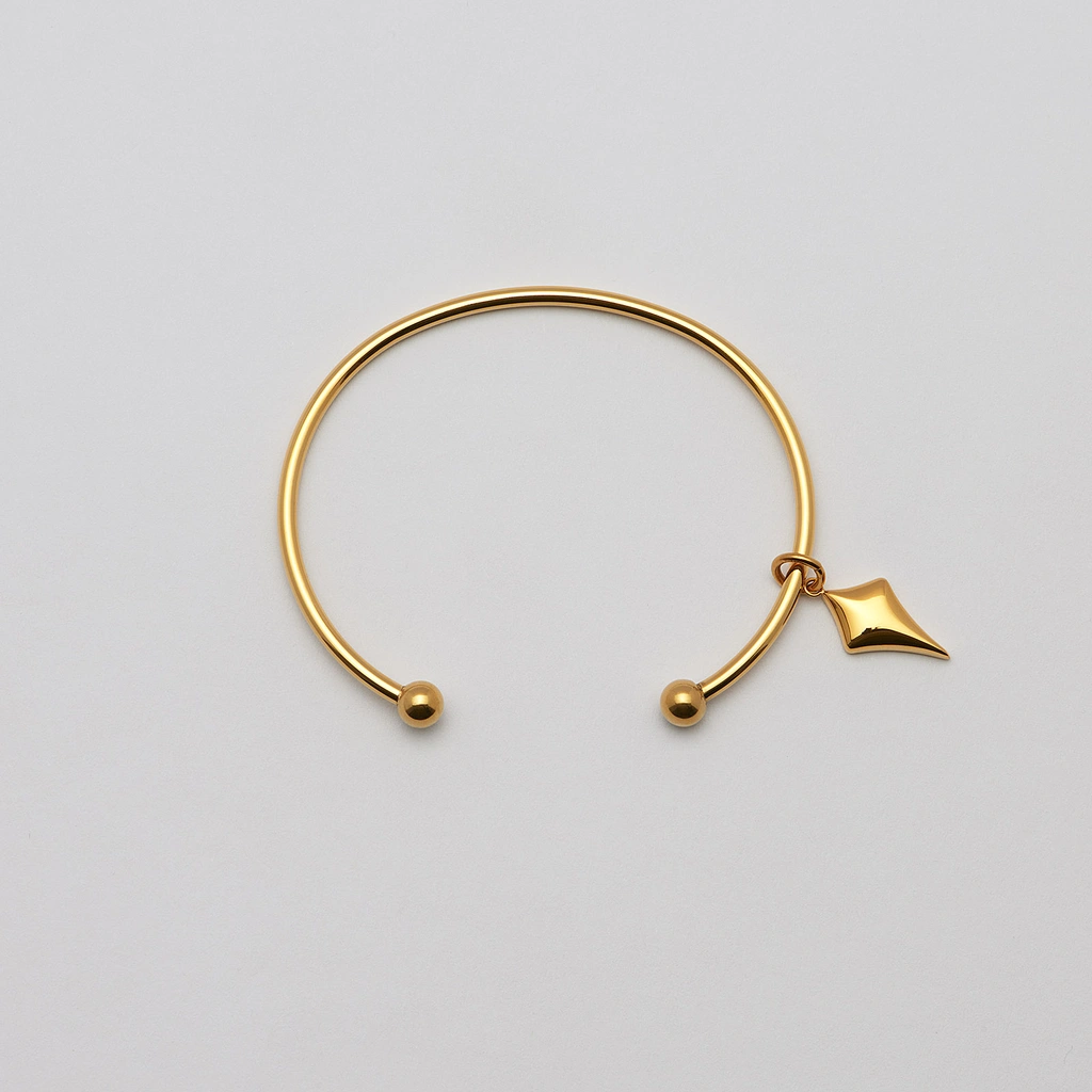 Armband i guldpläterat stål, bangle pil- 66,5 mm